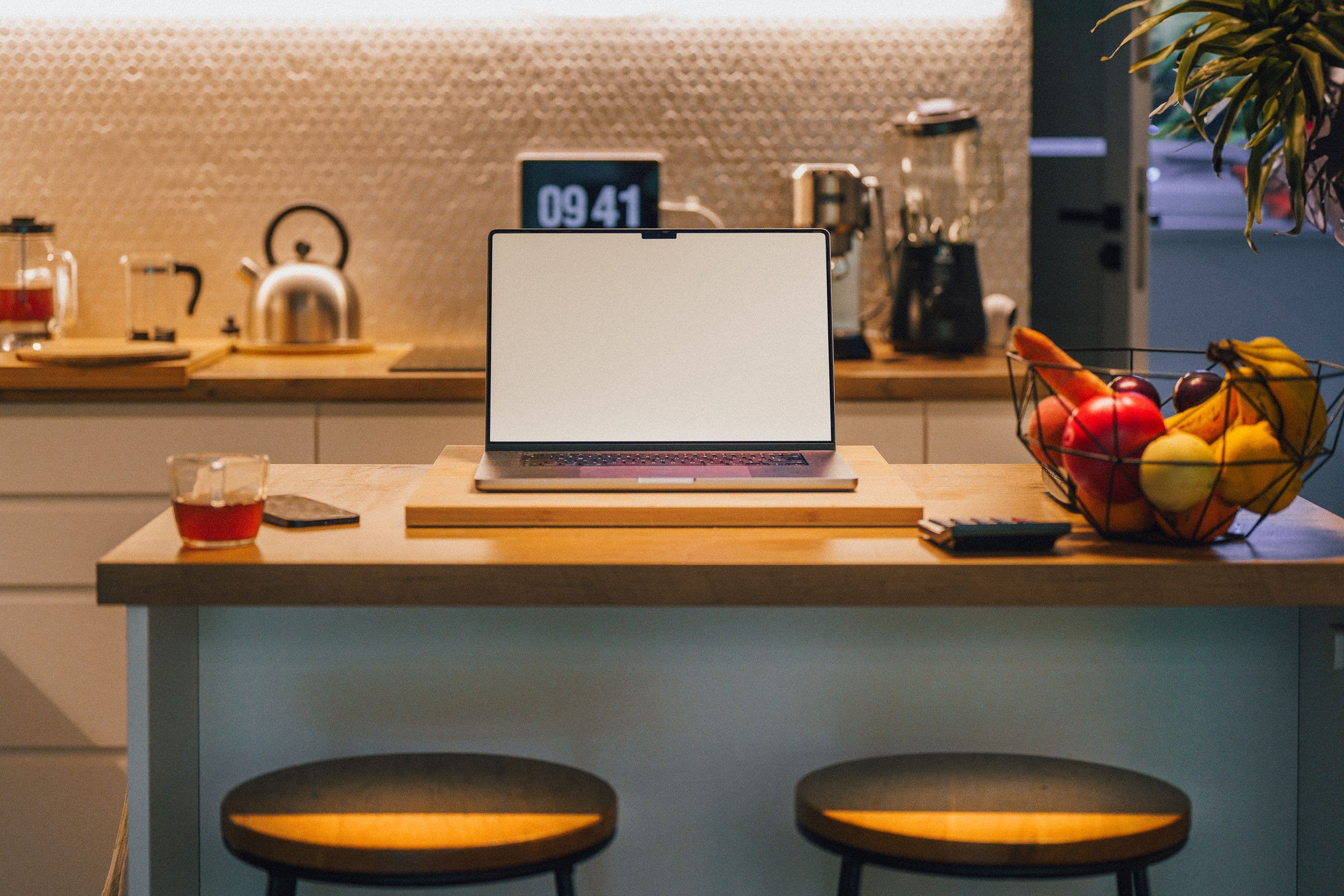 A kettle steaming on a kitchen counter in morning light, a phone resting beside it.