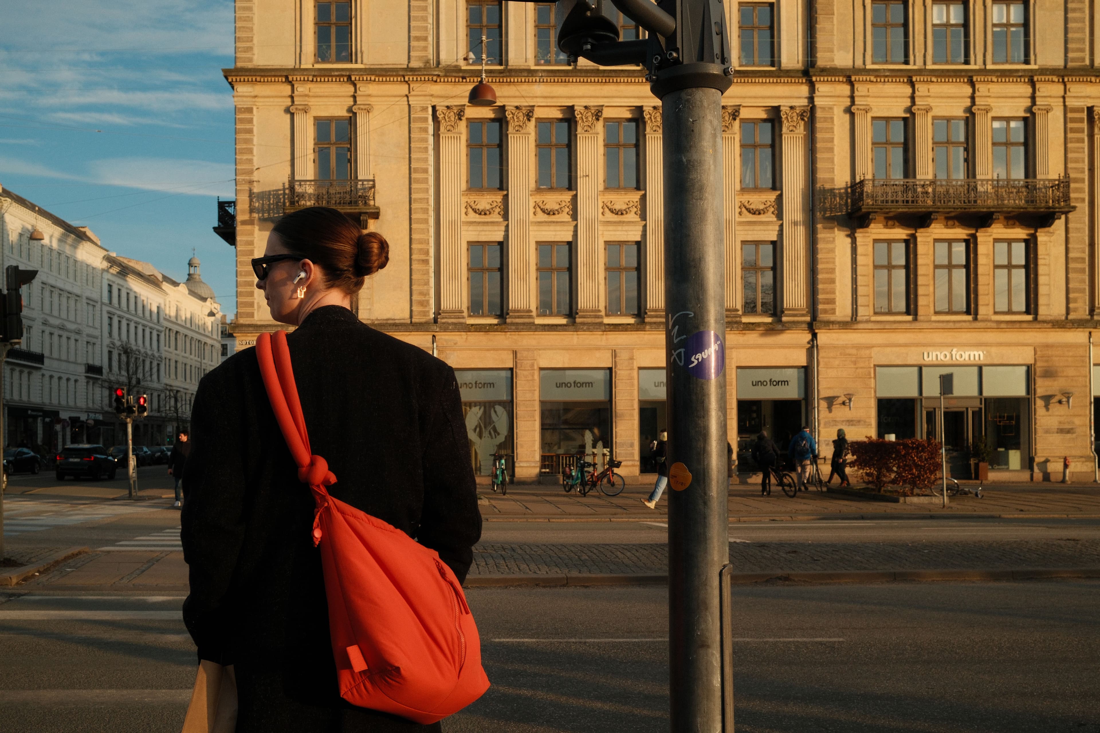 A person walking a quiet morning path with earbuds in and their phone in a pocket.